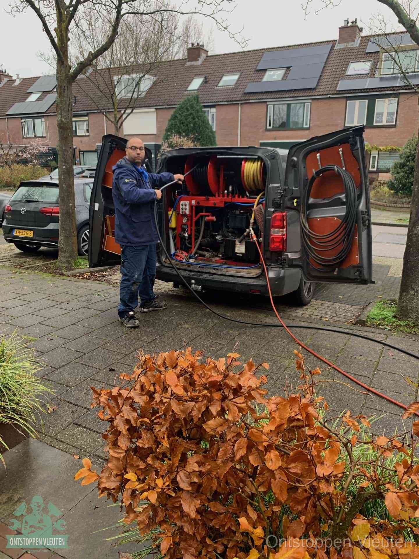 Monteur met rioolreinigingsbus levert rioolservice in de wijk in Vleuten