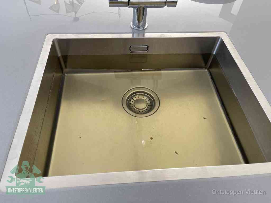 Stilstaand water in een rvs spoelbak dat niet wegloopt, een duidelijk signaal van een gootsteenverstopping in Vleuten