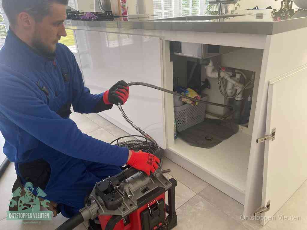 Een monteur reinigt de keukenafvoer grondig met een veermachine om terugkerende gootsteenverstoppingen te voorkomen in Vleuten